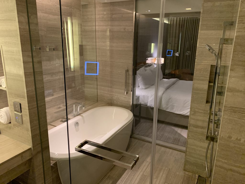 曼谷希爾頓素坤逸酒店-浴缸及淋浴間共處一室，兼且有玻璃簾子可望向房間