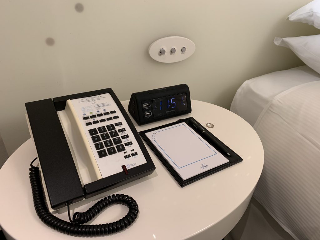 東京灣希爾頓酒店-房間左邊床頭櫃放置了電話、鬧鐘、便條簿及燈制按鈕