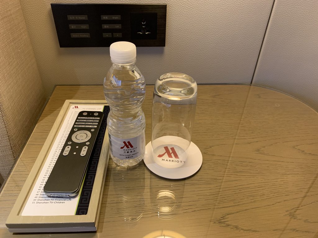 深圳中洲萬豪酒店-房間床頭櫃有電視遙控、免費樽裝水及水杯